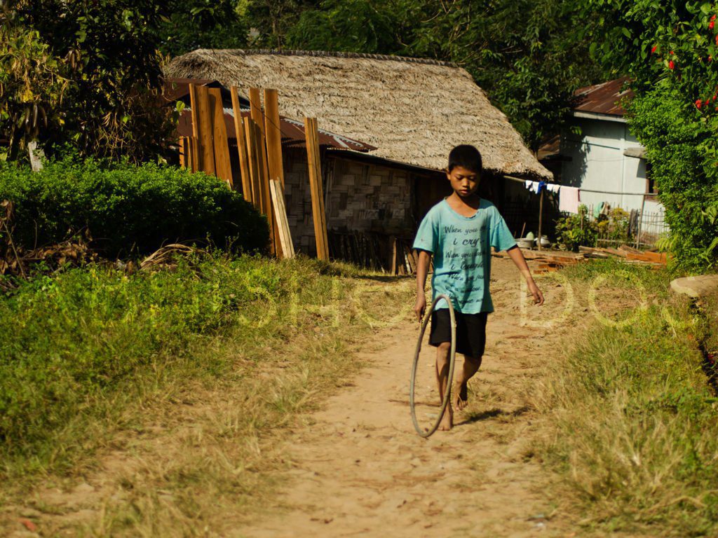 Travelling to Headhunter Basti Mon a child playing with rubber tube