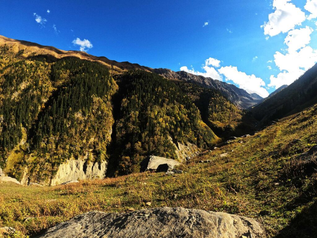 a lush green valley- beyond a vast range of mountains