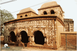 The superb terracotta carvings of floral patterns on the wall with a curved roof